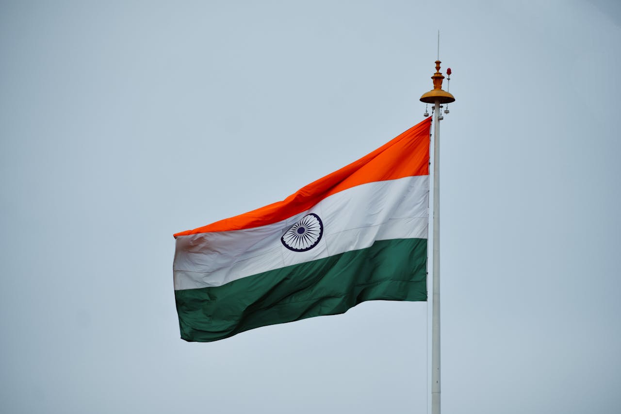 gallery-3 A vibrant Indian flag waving proudly on a flagpole against a clear blue sky.