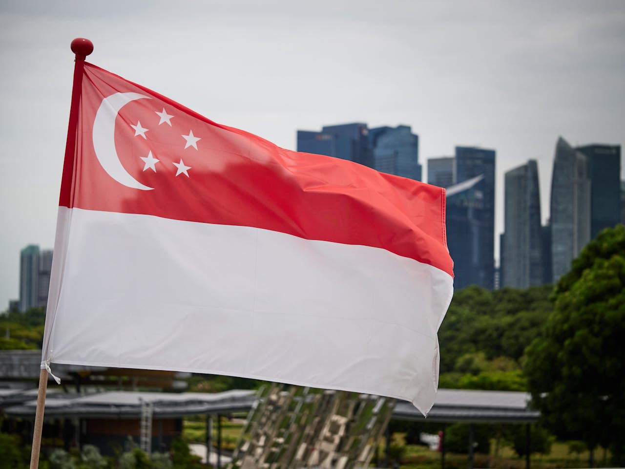 services-01 Singapore national flag waving with city skyline backdrop, symbolizing pride and modernity.